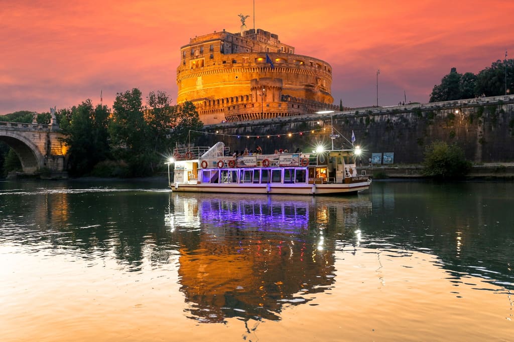Battello sul Tevere al tramonto davanti a Castel Sant'Angelo