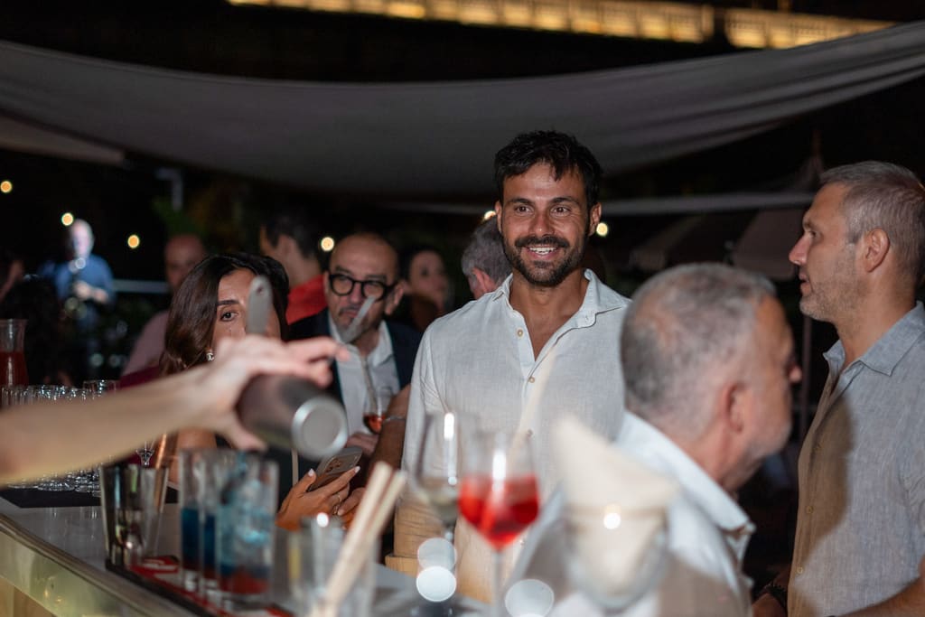 Ospiti sorridenti al bar della terrazza durante un evento serale