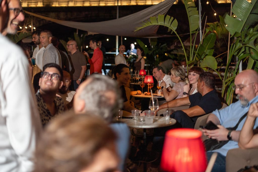 Tavolini con lampade rosse in terrazza di sera